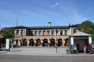 Frontalansicht des Erlanger Bahnhofes mit Bahnhofsplatz im Vordergrund