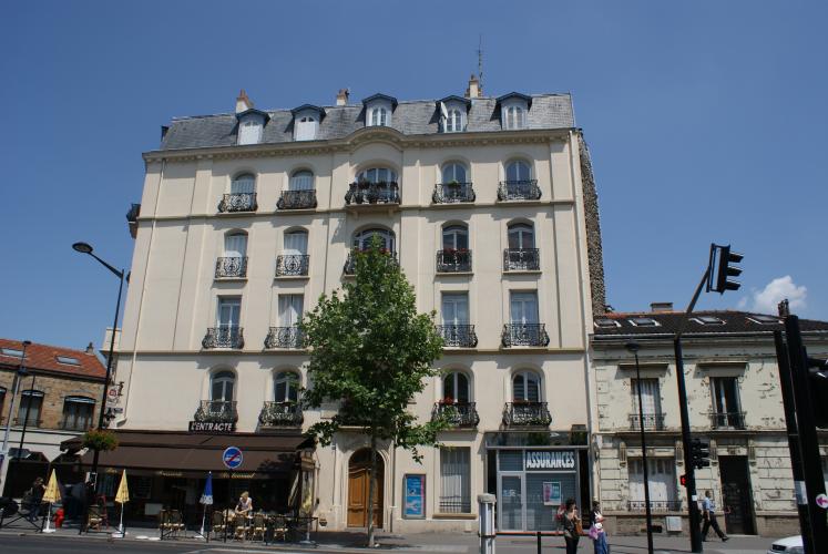 Ein Gebäude in Aubervilliers mit einem Restaurant und einem kleinen Laden im Erdgeschoss