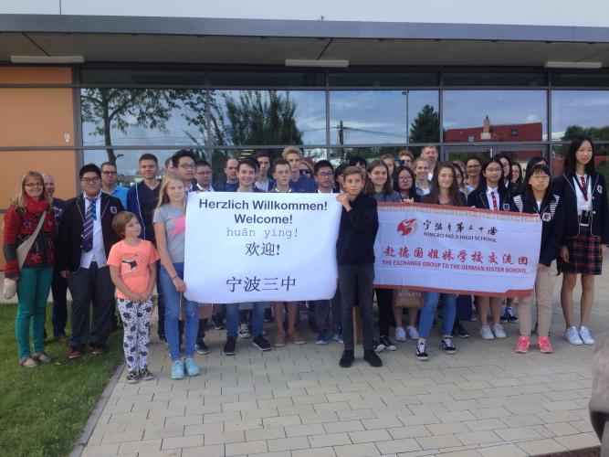 Schüler des EAG Jena und ihre Gäste der High School Nr.3 aus Ningbo halten vor dem Gymnasium in Jena "Herzlich Willkommen" Banner anlässlich des Austauschs 2017 hoch