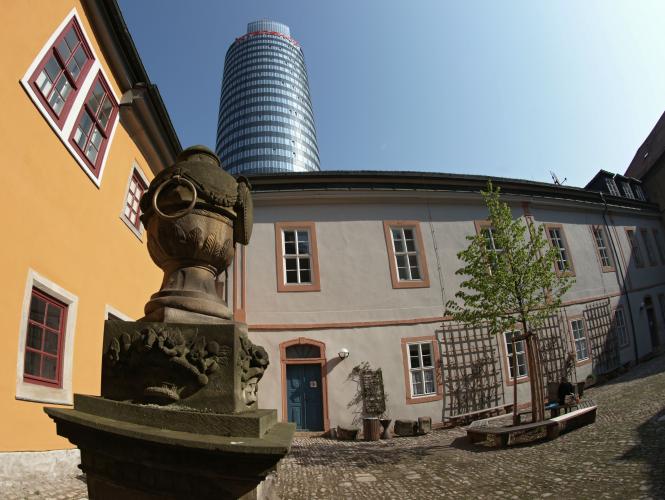 Die Gründungsstätte der Universität Jena von 1558. Im Hintergrund ragt der moderne Jentower in den blauen Himmel