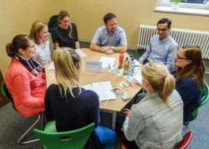 Schüler und Schülerinnen der Stoy-Schule Jena sitzen gemeinsam mit OB Dr. Thomas Nitzsche um einen runden Tisch und tauschen sich über Anliegen der jungen Menschen aus. 