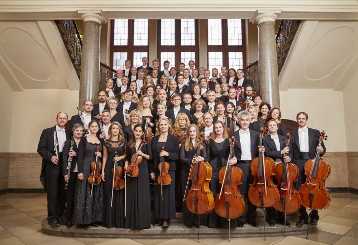 Die Musiker der Jenaer Philharmonie mit ihren Instrumenten. Sie sind elegant in schwarz-weiß gekleidet.